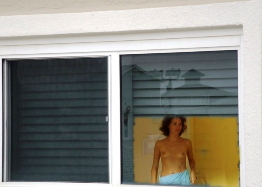 Nude women voyeured through window